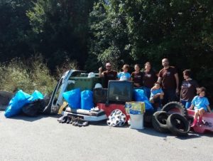 Participantes na limpeza simultánea de ríos con mostra de residuos retirados: neumáticos, electrodomésticos e outro lixo