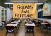 Aula baleira con cartaz de Fridays for Future diante da pizarra